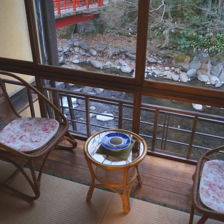 Типичный для традицинной гостиницы уголок у широкого раздвижного окна с двумя креслами; Сидзуока