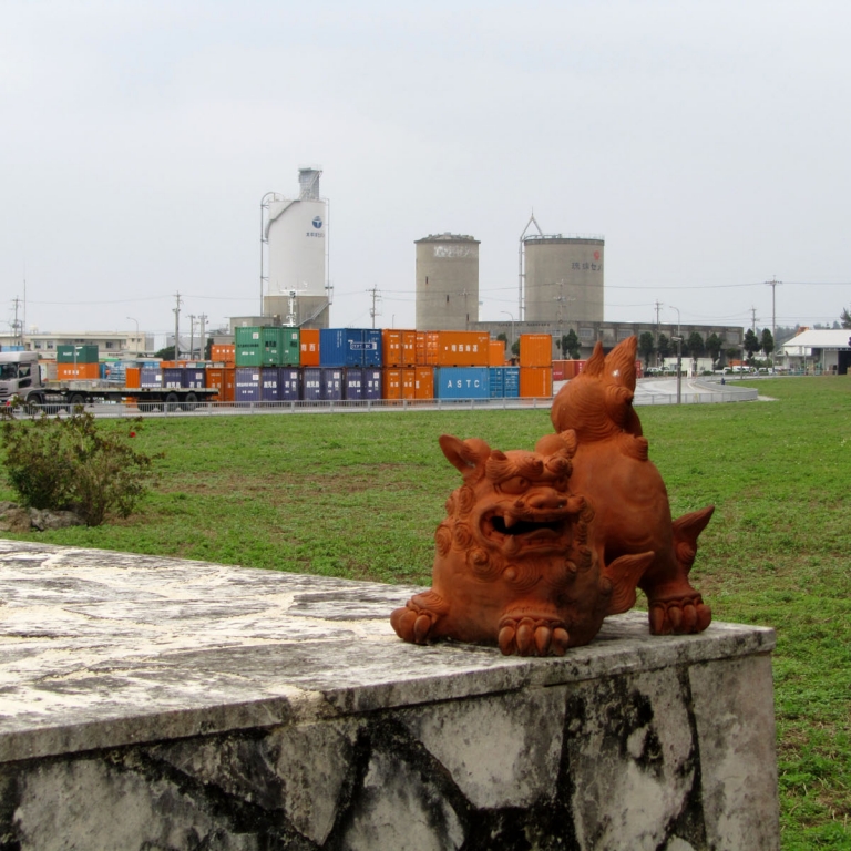 Диковинный окинавский талисман Сиса на фоне порта о.МиякоДзима; Окинава