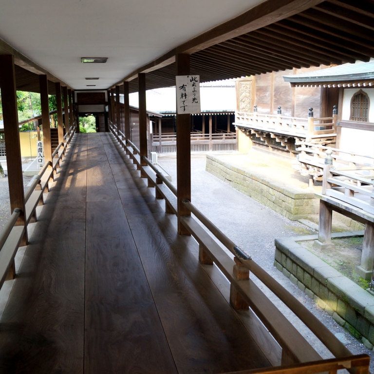Идеально ровный деревянный пол открытого коридора буддистского монастыря, который моют тряпками молодые монахи; Токио