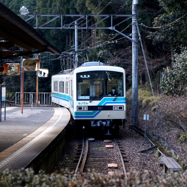 Состав из двух вагонов лини Эйдэн прибывает на конечную станцию КурамаЯма; Киото
