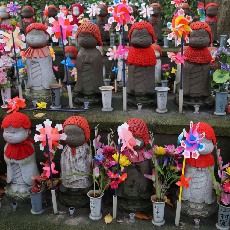 Одетые по-детски каменные фигурки в память о потерянных детях; Токио